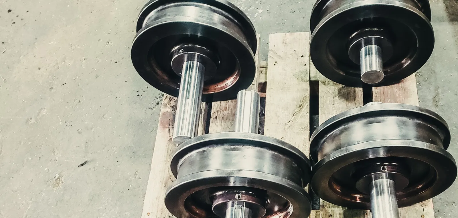 Transfer car crane wheel and axle assemblies staged on pallets at UTEC Industrial