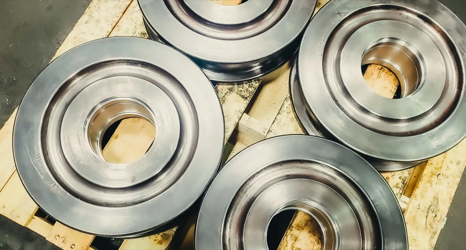 Finished crane wheels with flanged groove profile on pallet at UTEC Industrial
